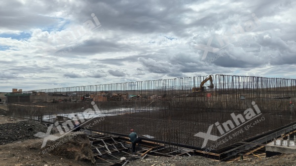 Workers tying rebar for a large foundation slab on the concentrator site